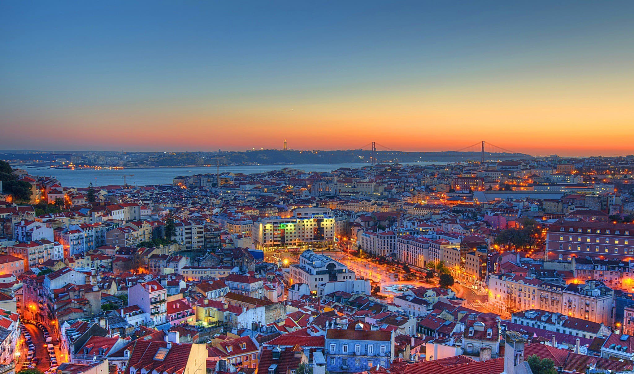 Vista panorâmica de Lisboa ao pôr do sol, sobre o rio Tejo e a Ponte 25 de Abril